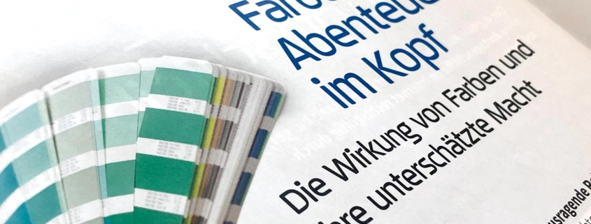 Beitragstitel im Werbemonitor "Farben sind Abenteuer im Kopf" mit Bild von Hand mit Farbfächer