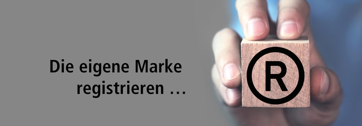 Die eigene Marke registrieren mit Hand, die Würfel mit Aufdruck Registered Trademark hält.
