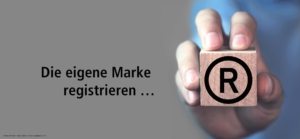 Die eigene Marke registrieren mit Hand, die Würfel mit Aufdruck Registered Trademark hält.