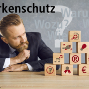 Unternehmer vor Pyramide aus Fragen zu Markenschutz