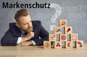 Unternehmer vor Pyramide aus Fragen zu Markenschutz