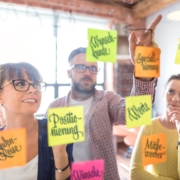 Personen beim Positionierungsworkshop vor Glaswand mit Zutaten für Markenpositionierung als Dienstleister in freien Berufen